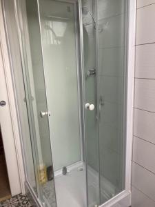 a shower with a glass door in a bathroom at Chambre meublée dans une maison in Vernouillet