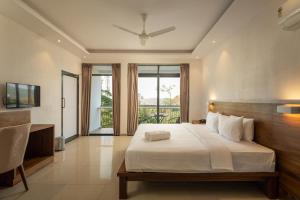 Winter Vale Green Stay Resorts في فاغامون: غرفة نوم بسرير كبير وبلكونة