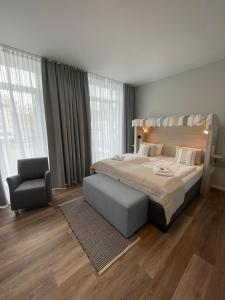 um quarto com uma cama grande e uma cadeira em Faldernpoort em Emden