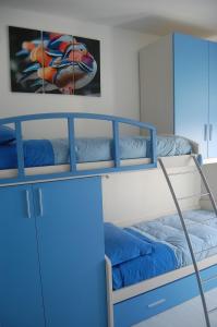 a bunk room with blue bunk beds and a mirror at Appartamento Giovanni in Lido Adriano