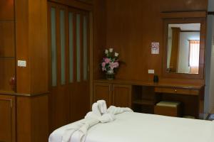 1 dormitorio con 1 cama, espejo y flores en Haadrin Resort, en Haad Rin