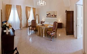 a living room with a table and chairs and a bed at Palazzo Volta Boutique Luxury B&B in Nardò