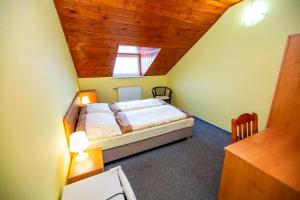 1 dormitorio con cama y techo de madera en Penzion Myslivna, en Lednice