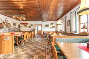 a restaurant with wooden ceilings and tables and chairs at Berggasthof Hinterreit in Maria Alm am Steinernen Meer