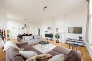 een woonkamer met een bank en een tafel bij SurPRIMO - Gerenoveerd appartement in Antwerpen
