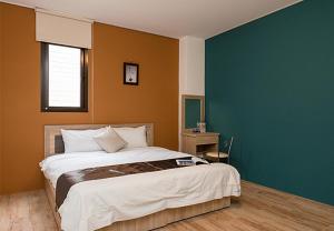 - une chambre avec un grand lit et un mur bleu dans l'établissement Shan Hao Homestay, à Yilan