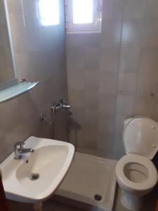 uma casa de banho com um WC branco e um lavatório. em Xrysafis Apartments em Nea Vrasna