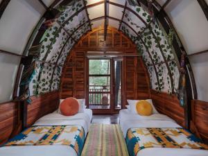 a room with three beds in a train at The Lodge Maribaya in Lembang