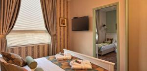 a hotel room with towels on a bed and a mirror at Casa Boutique Hotel in Nahariyya