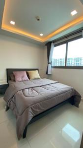 um quarto com uma cama grande e uma janela em Arcadia Beach Continental em South Pattaya