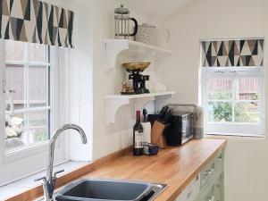 cocina con fregadero y encimera en Windmill Cottage, en Little Eaton