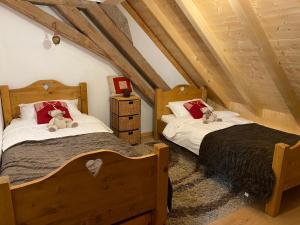 dwa łóżka z pluszowymi misiami na poddaszu w obiekcie Le Bel appartement de Montagne w mieście Bellevaux