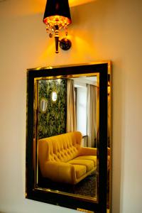a mirror with a yellow couch in a living room at Hotel Pruski in Orneta