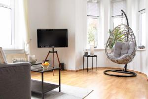 a living room with a chair and a tv at Villa Elbblick mit Garten in Tangermünde