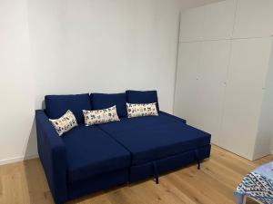 un divano blu in un soggiorno con cuscini di Monolocale nel cuore di Genova a Genova