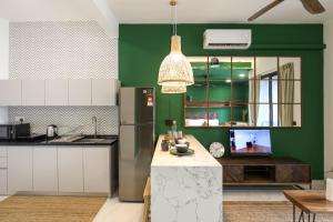 a kitchen with green and white walls and a refrigerator at Peaceful Studio w Pool for 3 Pax - Seri Kembangan in Seri Kembangan