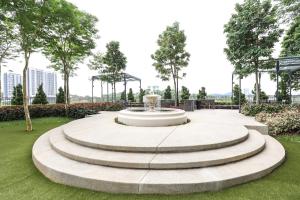 a fountain in a park with grass and trees at Peaceful Studio w Pool for 3 Pax - Seri Kembangan in Seri Kembangan