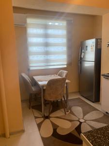a small kitchen with a table and a refrigerator at Dream Home in Baku
