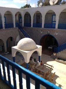 a blue and white building with a table and a balcony at Hôtel Sindbad in Houmt Souk