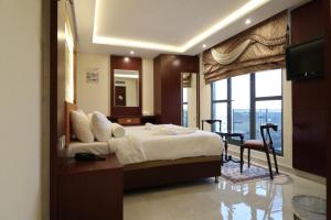 索哈尔Tribes hotel的一间卧室，配有一张床、一张书桌和一扇窗户