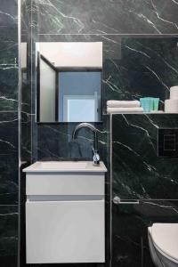 a bathroom with a sink and a mirror at Liber Tel Aviv Sea Shore Suites BY RAPHAEL HOTELS in Tel Aviv