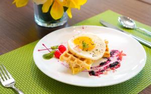 a white plate with an egg on top of waffles at Hampton by Hilton Shenzhen Yuanshan in Shenzhen