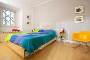 a bedroom with a bed and a yellow chair at Gli Appartamenti Dell' Architetto in Trapani