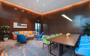 een vergaderzaal met een tafel en stoelen en een bank bij Hampton by Hilton Shenzhen Yuanshan in Shenzhen