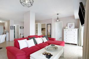 a living room with a red couch and a white table at Apartamentos Tamara in Tacoronte