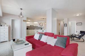 uma sala de estar com um sofá vermelho e uma cozinha em Apartamentos Tamara em Tacoronte
