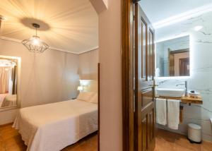 a bedroom with a bed and a sink and a mirror at Logis Hotel Restaurante La Casa de Juansabeli in Arenas de Cabrales +214 photos