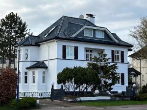 a white house with a black roof at Villa Altstadt Westhafen in Wismar