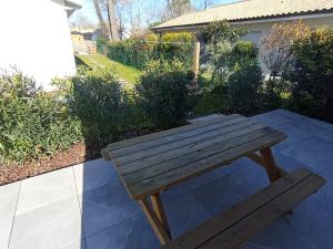 drewniana ławka na patio w obiekcie Jolie petite maison w mieście Sanguinet