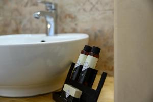 a bathroom with a sink and two bottles of lipstick at Afroditi Superior Apartments in Archangelos +37 photos