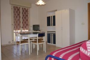 リド・デッレ・ナツィオーニにあるAppartamenti Tropiciのテーブルと椅子、キッチンが備わる客室です。