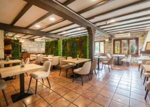 a restaurant with tables and chairs and plants at Logis Hotel Restaurante La Casa de Juansabeli in Arenas de Cabrales