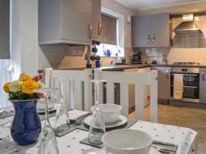 a kitchen with a table with a vase of flowers on it at Lapwing Lodge in New Hunstanton