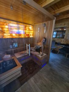 a woman sitting in a sauna with a tub at Thermae D'Olimpia & SPA - Adults Only 14 Plus in Băile Herculane