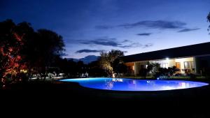 a large blue pool in front of a building at night at Ana-as Apartelle (GGL) in Panglao Island