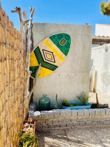 a surfboard painted on the side of a wall at Maisonnette climatisée à 35m de la plage de La Capte Hyères in Hyères