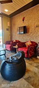 - un salon avec deux canapés rouges et un canapé dans l'établissement Green Meadows Farm Stay, à Chandoli