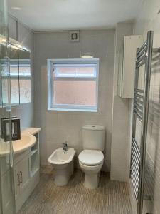 a small bathroom with a toilet and a sink at G-Floor Flat with 2 beds, 2 bathrooms, slips 4-6 in West Bridgford