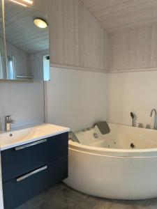 y baño con bañera, lavamanos y bañera. en Kapitänshus-Strandpark 24, en Grömitz