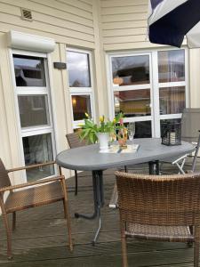 einen Tisch auf einer Veranda mit zwei Stühlen und einer Pflanze in der Unterkunft Kapitänshus-Strandpark 24 in Grömitz