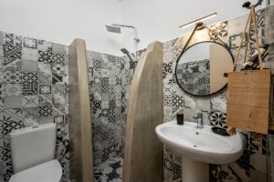 ein Badezimmer mit einem Waschbecken, einem WC und einem Spiegel in der Unterkunft Afroditi Superior Apartments in Archangelos