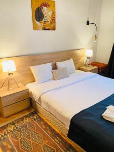 a bedroom with a bed and two lamps in it at Piccolo Casa Bella Hotel in Tbilisi City
