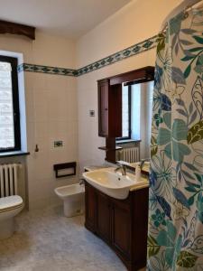 uma casa de banho com um lavatório e um WC em Appartamento con giardino em Pomarance