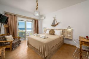 a bedroom with a bed with a view of the ocean at Afroditi Superior Apartments in Archangelos