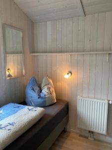 Habitación pequeña con cama y almohada en Kapitänshus-Strandpark 24 en Grömitz