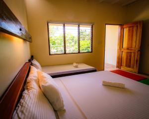 - une chambre avec un grand lit et une fenêtre dans l'établissement Ana-as Apartelle (GGL), à Panglao